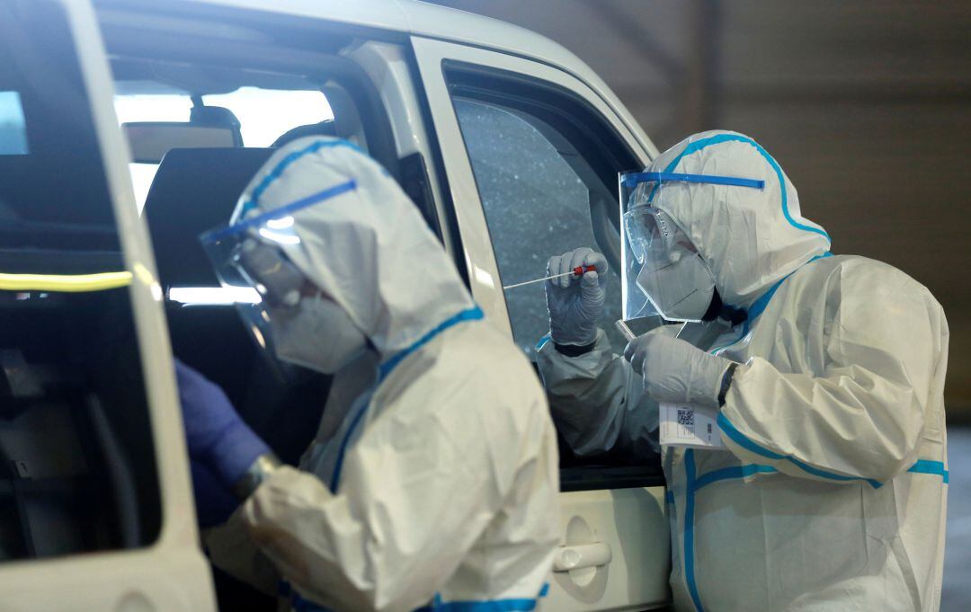 Medical personnel tests a person at a drive-in testing site at an out-of-service aircraft hangar at Guetersloh Airport following an outbreak of the coronavirus disease (COVID-19) in Guetersloh, Germany, Germany June 27, 2020