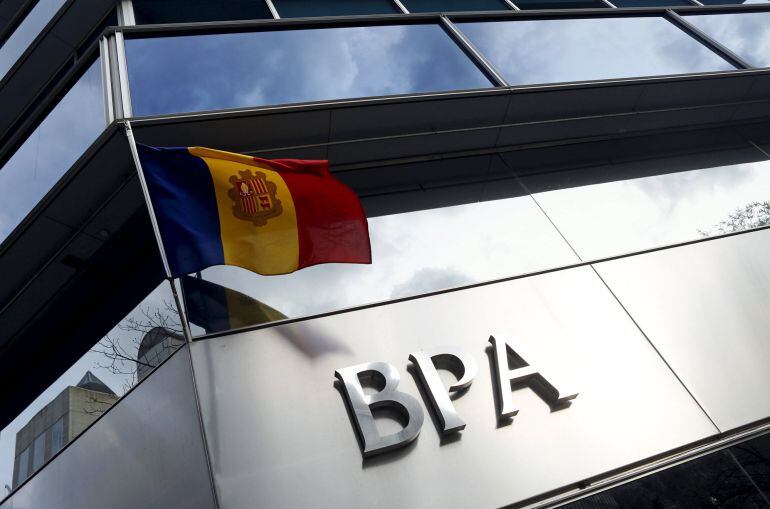 An Andorran national flag flies next to a Banca Privada d'Andorra (BPA) office in Andorra la Vella March 29, 2015. Andorra will create a 'bad bank' to group the assets of BPA linked to illicit activity, it said late on Thursday, as the principality battles to rebuild the reputation of its banking system. REUTERS/Albert Gea 