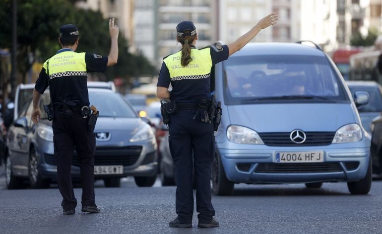 GRA160. VALENCIA, 22/09/2015.- La ciudad de Valencia celebra el Día sin coches con el cierre al tráfico de la Plaza del Ayuntamiento, que se convierte en un espacio con exposiciones, actividades infantiles y un punto de información, en una jornada donde los autobuses municipales y el metro son gratuitos.En la imagen, la policia local corta el trafico a todos los vehiculos menos a las bicicletas en el acceso al centro histórico de la ciudad. EFE/Kai Forsterling