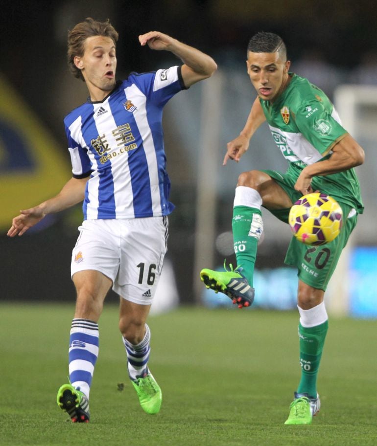 GRA463. SAN SEBASTIÁN, 28/11/2014.- El jugador francés del Elche Faycal Fajr (d) juega un balón ante Sergio Canales, de la Real Sociedad, durante el partido de Liga en Primera División disputado esta noche en el estadio de Anoeta, en San Sebastián. EFE/Juan Herrero.