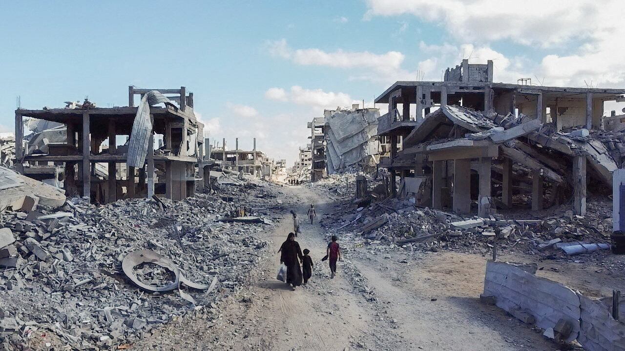 Imágenes de dron muestran a varios palestinos desplazados entre las ruinas de edificios en Gaza, este domingo.