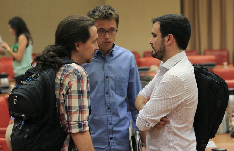 El secretario general de Podemos, Pablo Iglesias, conversa con el secretario político de la formación, Íñigo Errejón y con el líder de IU, Alberto Garzón.