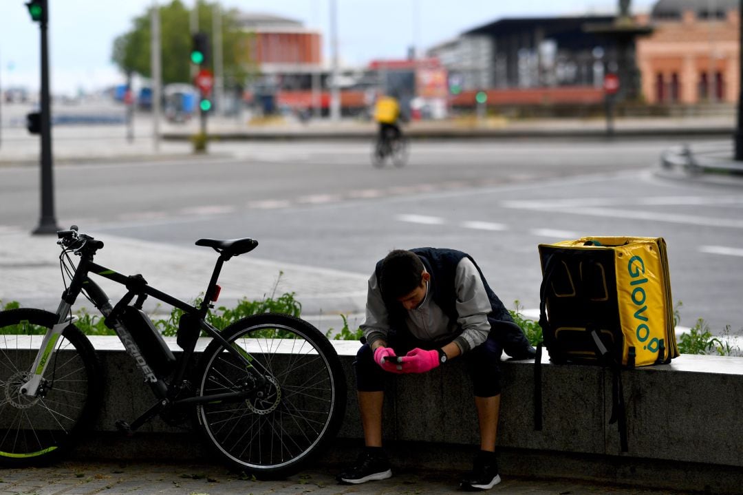 Un trabajador de Glovo, frente a la estación de Atocha de Madrid. 