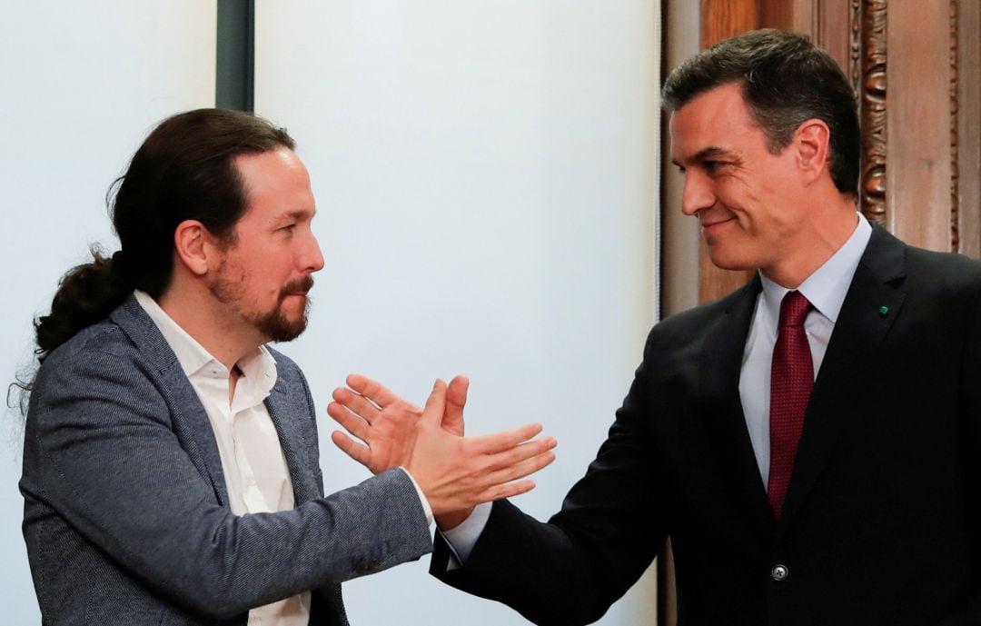 Pedro Sánchez y Pablo Iglesias estrechan manos ante el nuevo Gobierno de coalición.