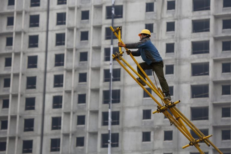 WUHONG03 PEKÍN (CHINA) 20/01/2015.- Un obrero trabaja sobre un andamio para encofrado en las obras de construcción de un edificio dePekín (China), hoy, 20 de enero de 2015. El PIB de China aumentó un 7,4 % en 2014, el incremento más bajo desde 1990, según los datos oficiales divulgados hoy por el Gobierno de Pekín, cuyas previsiones situaban la cifra en el 7,5 %. EFE/Wu Hong