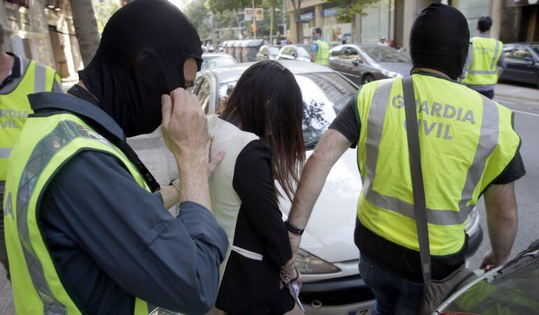 Agentes de la Guardia Civil acompañan a una de las mujeres liberadas en la operación.