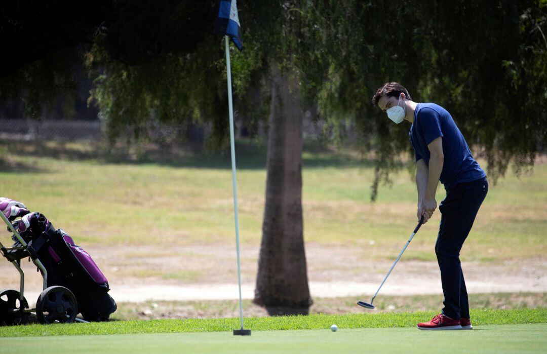 Un jugador de golf con mascarilla.