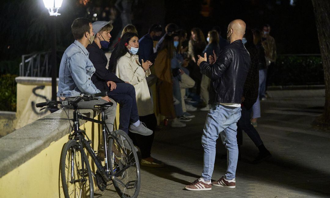 Un grupo de jóvenes con las mascarillas bajadas.