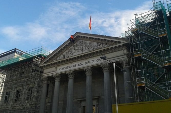 Activistas de Greenpeace han protestado en el Congreso durante el debate de la ley de Costas. Uno de los activistas ha escalado a lo más alto de la fachada principal del edificio, situado en la Carrera de San Jerónimo de Madrid