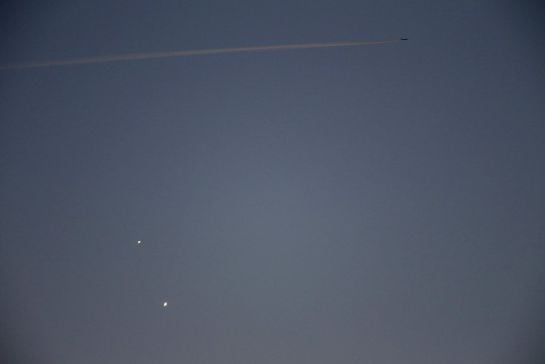 El planeta Venus (al centro) es visto cerca de Júpiter mientras una avioneta atraviesa el cielo de Gdynia, Polonia.