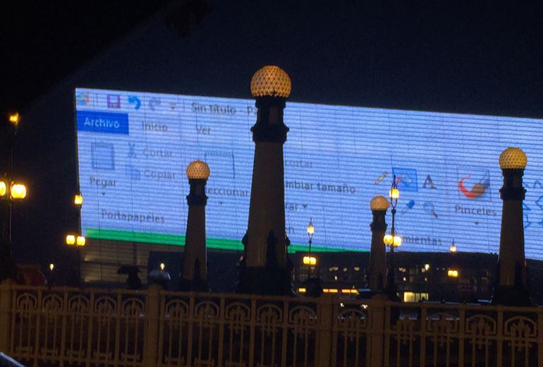 Fachada principal del Kursaal iluminada con la imagen del escritorio de un ordenador. 