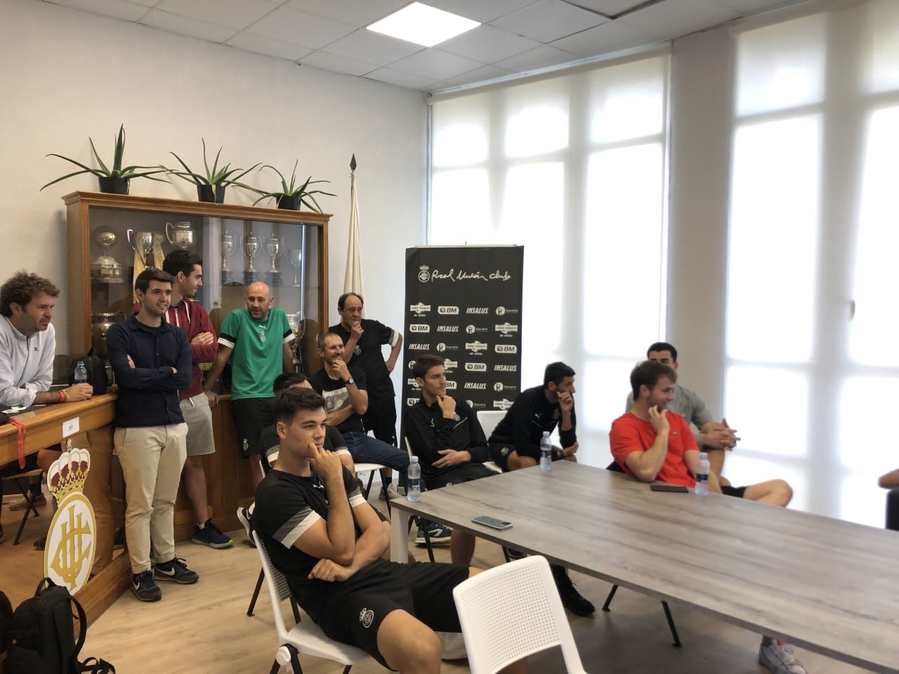 Jugadores y cuerpo técnico del Real Unión sigue el sorteo en la sala de juntas del Stadium Gal