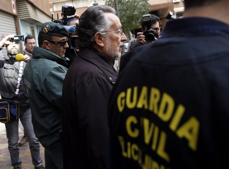 Agentes de la Guardia Civil escoltan al exvicealcalde de Valencia, Alfonso Grau, a la salida de su vivienda.