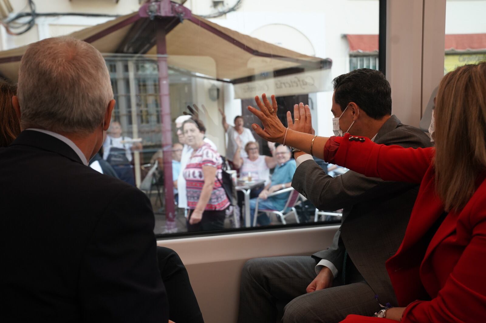 El presidente de la Junta, Juan Manuel Moreno Bonilla, saluda a vecinos de San Fernando al paso del tren tranvía