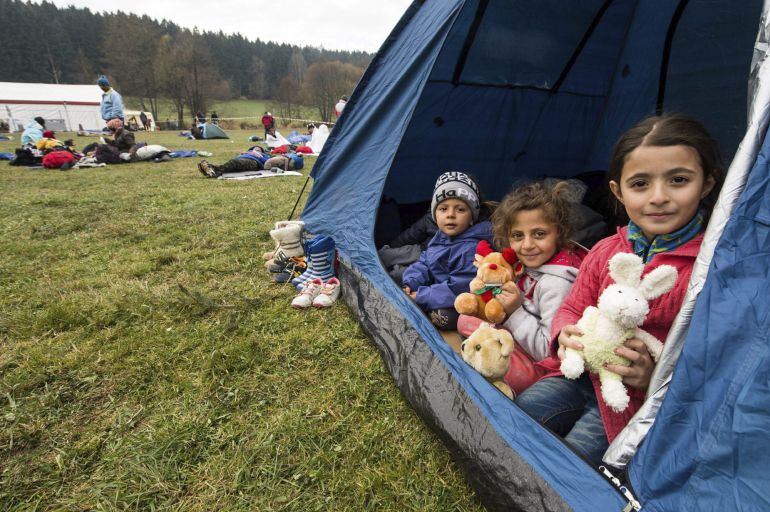 Niños refugiados sirios descansan en una tienda de campaña cerca de la frontera con Alemania en Hanging, Austria