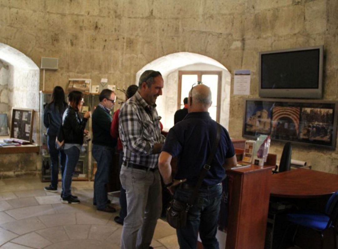 Un grupo de turistas esperan información en la Oficina de Turismo de Cuéllar.