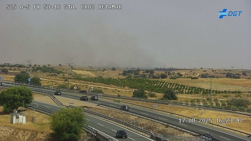 Al fondo, el humo generado por el incendio, visto desde una de las cámaras de la Dirección General de Tráfico en la Autovía A-5