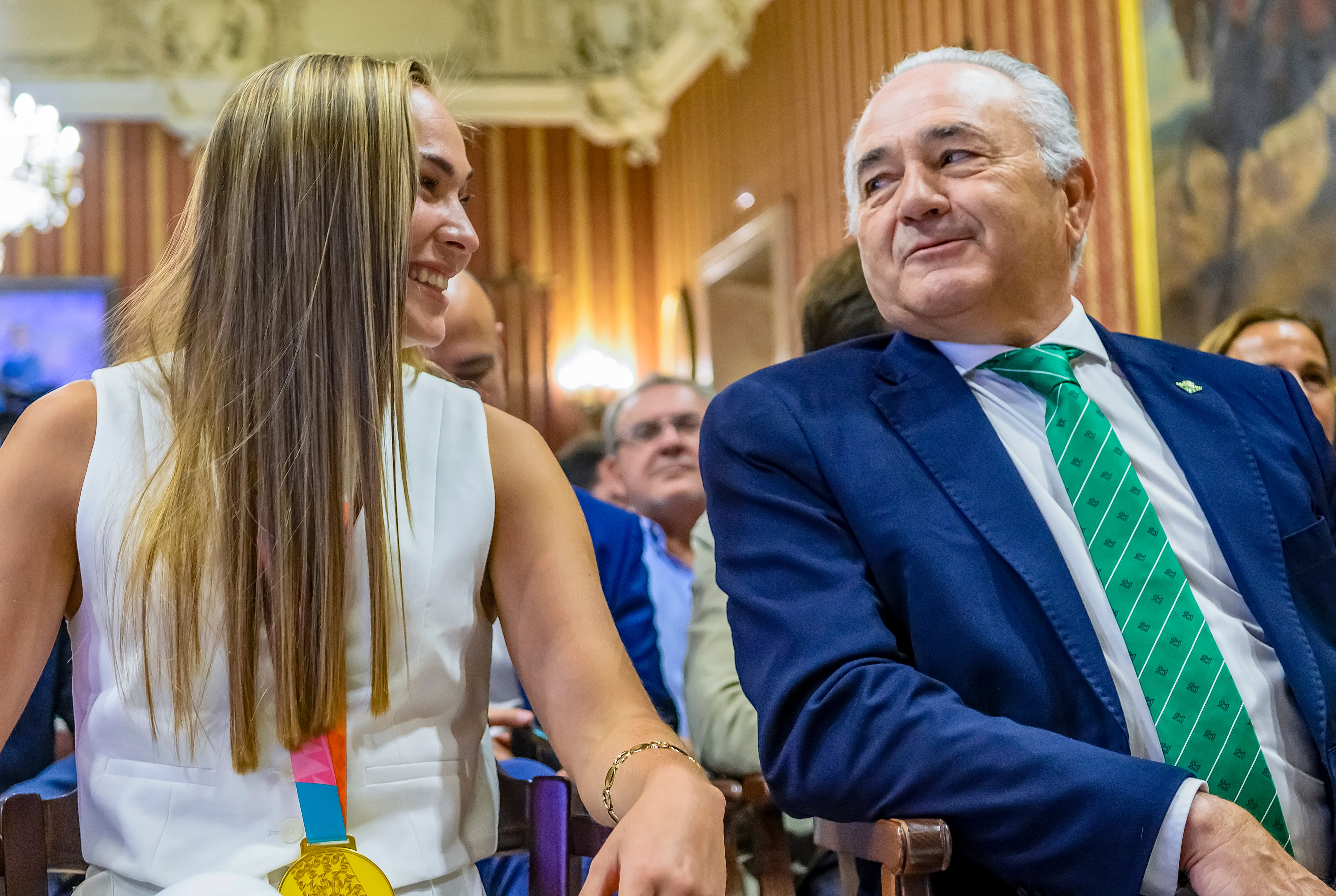 SEVILLA, 29/08/2023.- La jugadora de la selección española de fútbol Irene Guerrero, reciente campeona del mundo, acompañada por el presidente de la Fundación Real Betis, Rafael Gordillo, durante la recepción que el regidor andaluz, José Luis Sanz (i), ofrece este martes en el Salón Colón del Ayuntamiento de Sevilla. EFE/ Raúl Caro.
