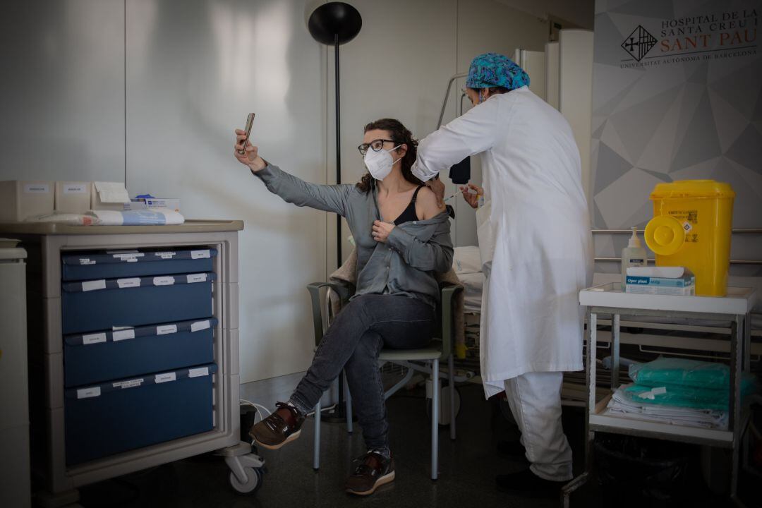 Una enfermera vacuna a un profesional sanitario con la vacuna de Pfizer-BioNtech