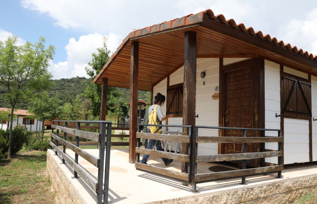 Una clienta entra en un bungalow del Camping Monte Holiday en Gargantilla del Lozoyal.