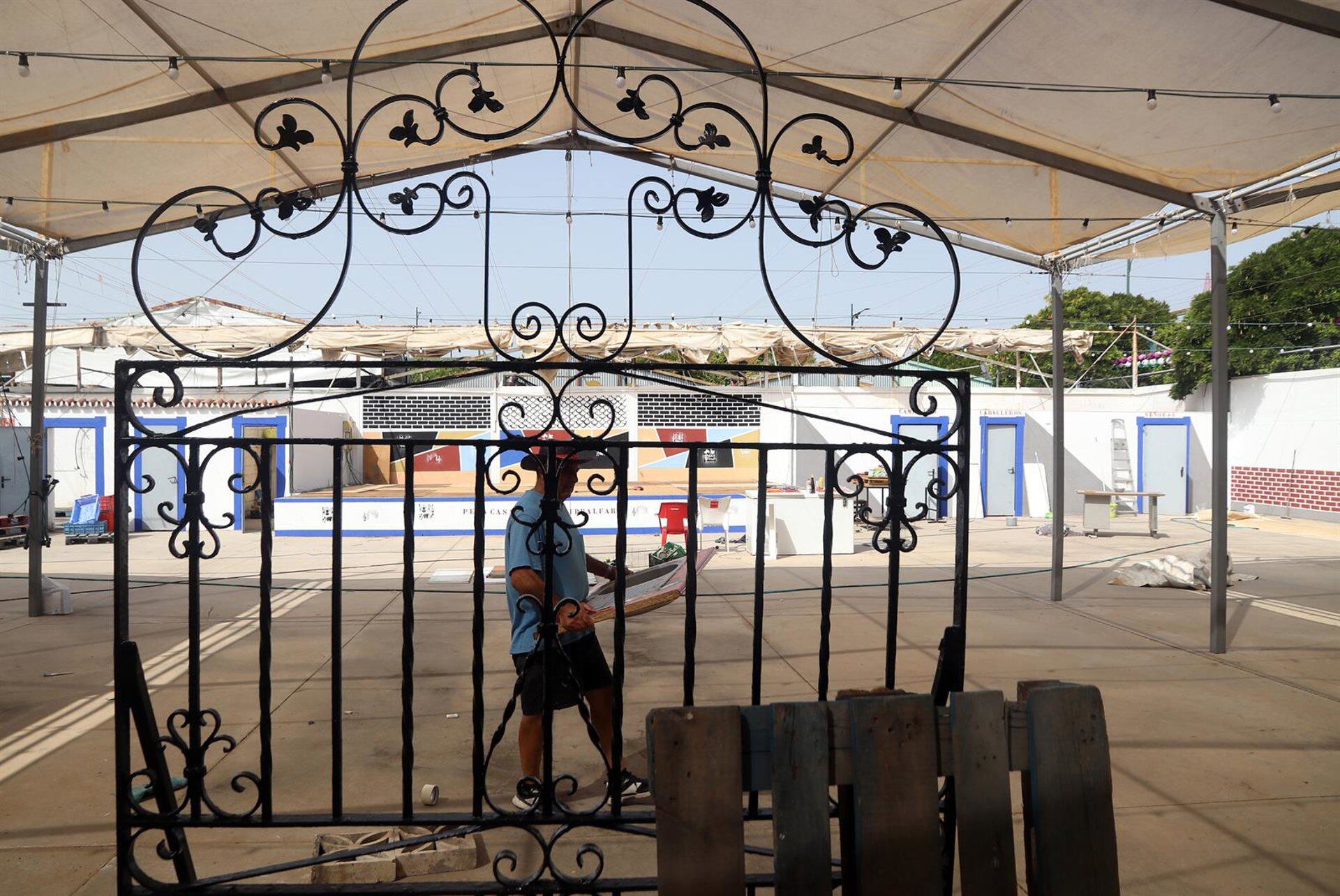 Operarios realizan tareas de montajes y arreglos en las casetas del Cortijo de Torres para la celebración de la Feria de Málaga