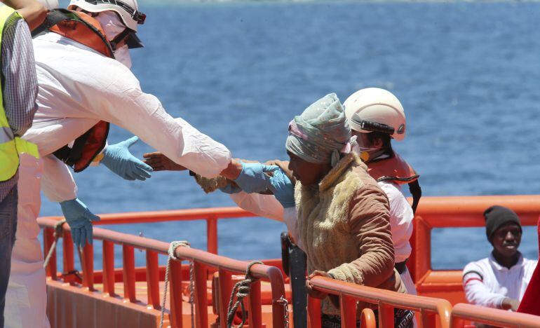 Un voluntario de Cruz Roja atiende en el muelle de Arguineguín (Mogán) a algunos de los 58 inmigrantes que Salvamento Marítimo rescató en aguas cercanas al sur de Gran Canaria