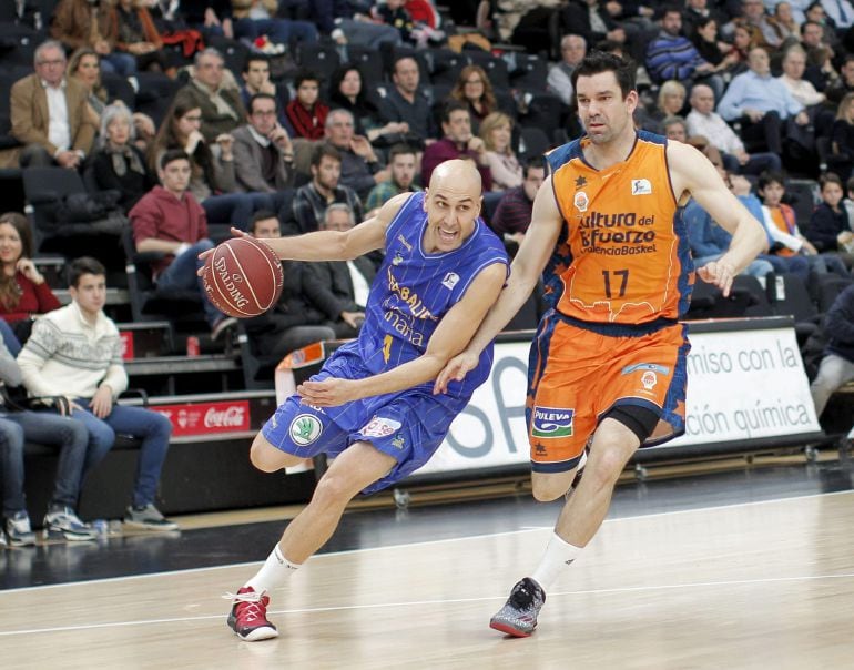 GRA106. VALENCIA, 21/12/2014. El base del Herbalife Gran Canaria, Albert Olivé, conduce el balón ante el escolta del Valencia Basket, Rafa Martínez, durante el partido correspondiente a la 12 jornada de la Liga jugado este mediodía en el pabellón de la Fuente de San Luis de Valencia. EFE/Manuel Bruque.