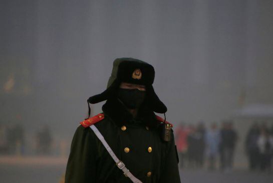 Un policía paramilitar se protege de la contaminación con una máscara en la plaza de Tiananmen.