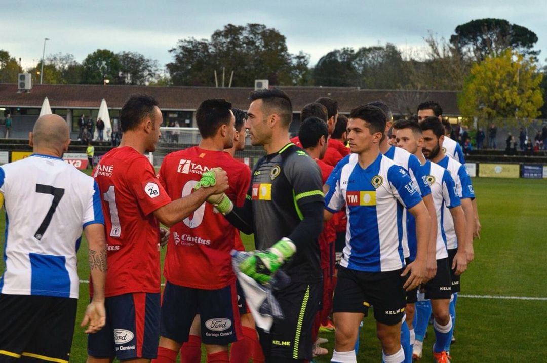 Los jugadores del Hércules y Olot se saludan antes del partido