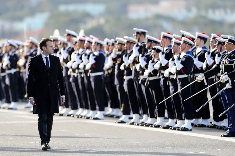 El presidente galo, Emmanuel Macron, pasa revista a la guardia de honor durante su visita al Dixmude, un buque de asalto anfibio, en la base naval gala de Toulon