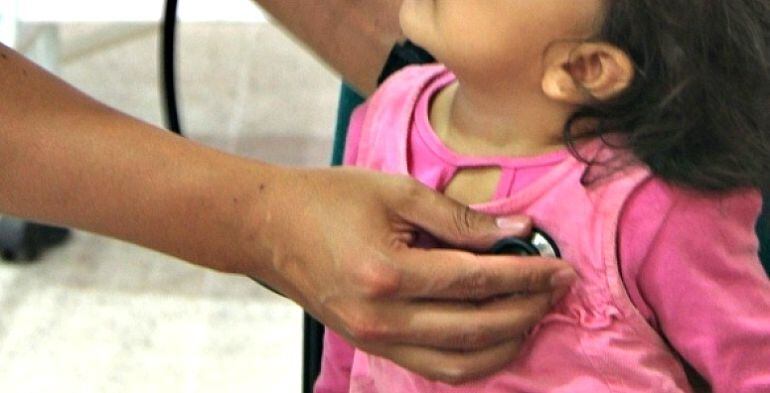 Niña siendo atendida por un médico