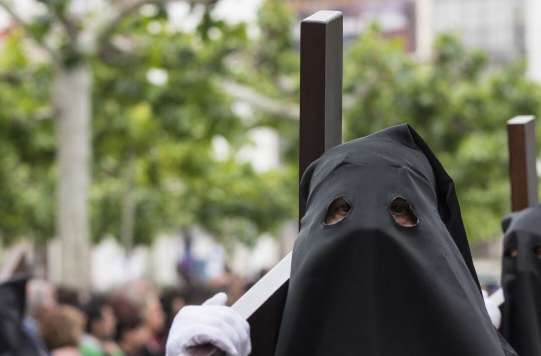 Un penitente carga con una cruz durante una procesión de Semana Santa.