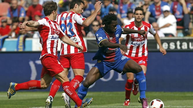 El delantero ecuatoriano del Levante UD Felipe Caicedo conduce el balón presionado por los jugadores del Sporting de Gijón Alberto Rivera y David Barral durante el partido, correspondiente a la trigésima cuarta jornada del Campeonato Nacional de Liga de P