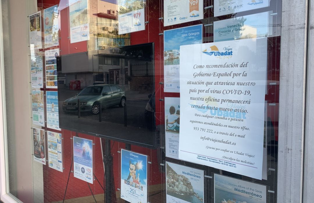 Escaparate de una agencia de viajes de Úbeda donde se informa a través de un cartel del cierre temporal por el Covid-19