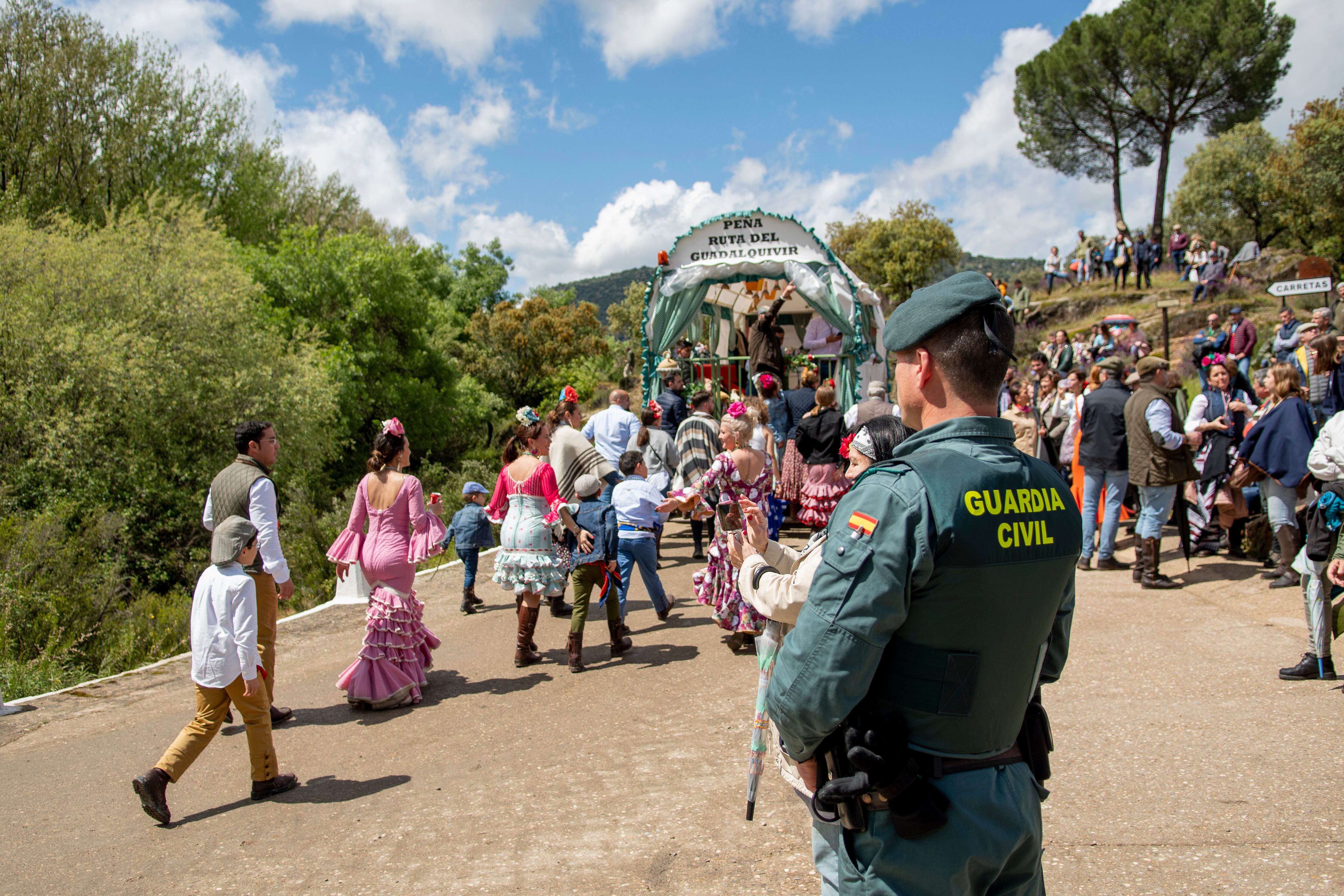 Un guardia civil observa la comitiva de carretas en la subida al Cerro.