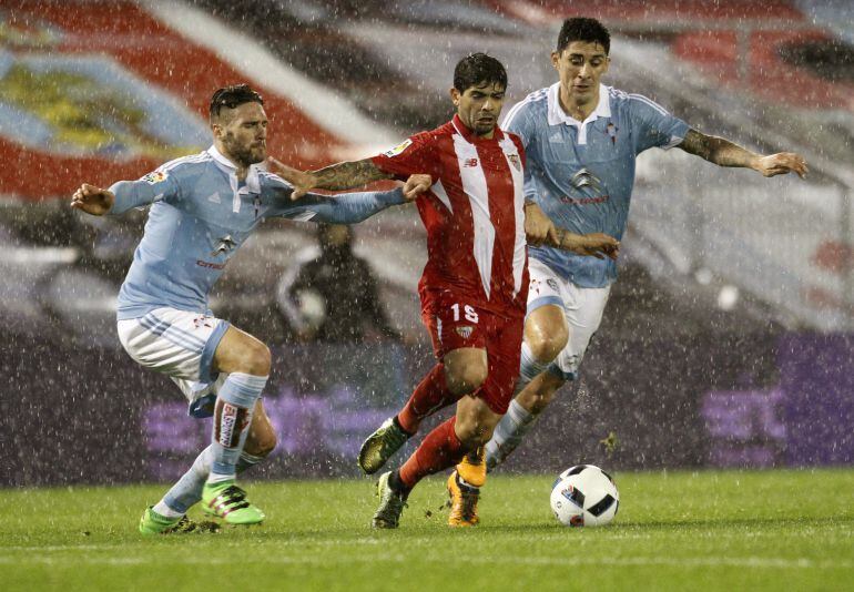 Éver Banega intenta zafarse de la defensa del Celta.