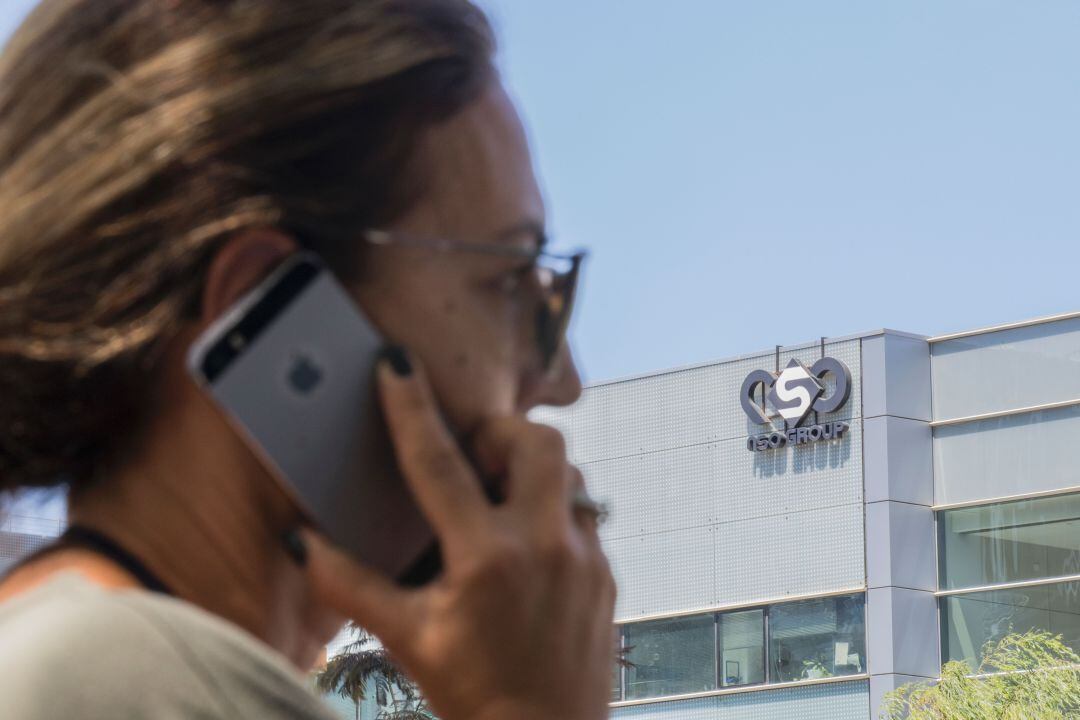 Una mujer israelí utiliza su móvil frente a la sede de la empresa NSO Group.