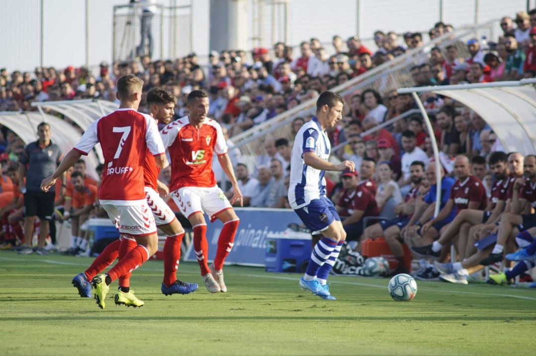 Tres jugadores del Murcia luchan un balón en el primer partido de pretemporada ante el Levante