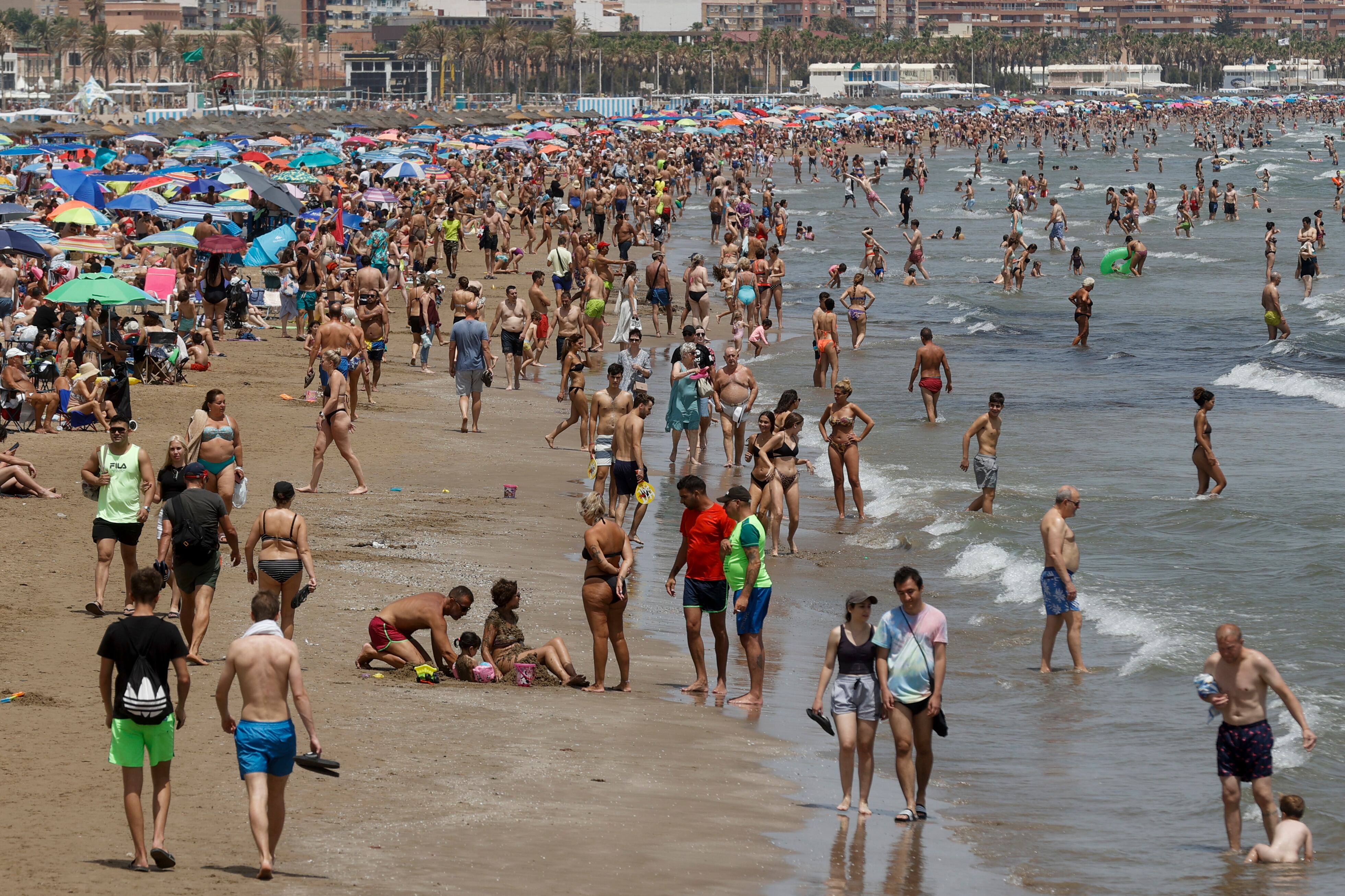 GRAFCVA6979. VALENCIA, 03/07/2022.- Vista general de la playa de la Malvarrosa adonde ha acudido un gran número de personas para disfrutar de las altas temperaturas y del buen tiempo general de este primer fin de semana de julio. EFE/Kai Försterling