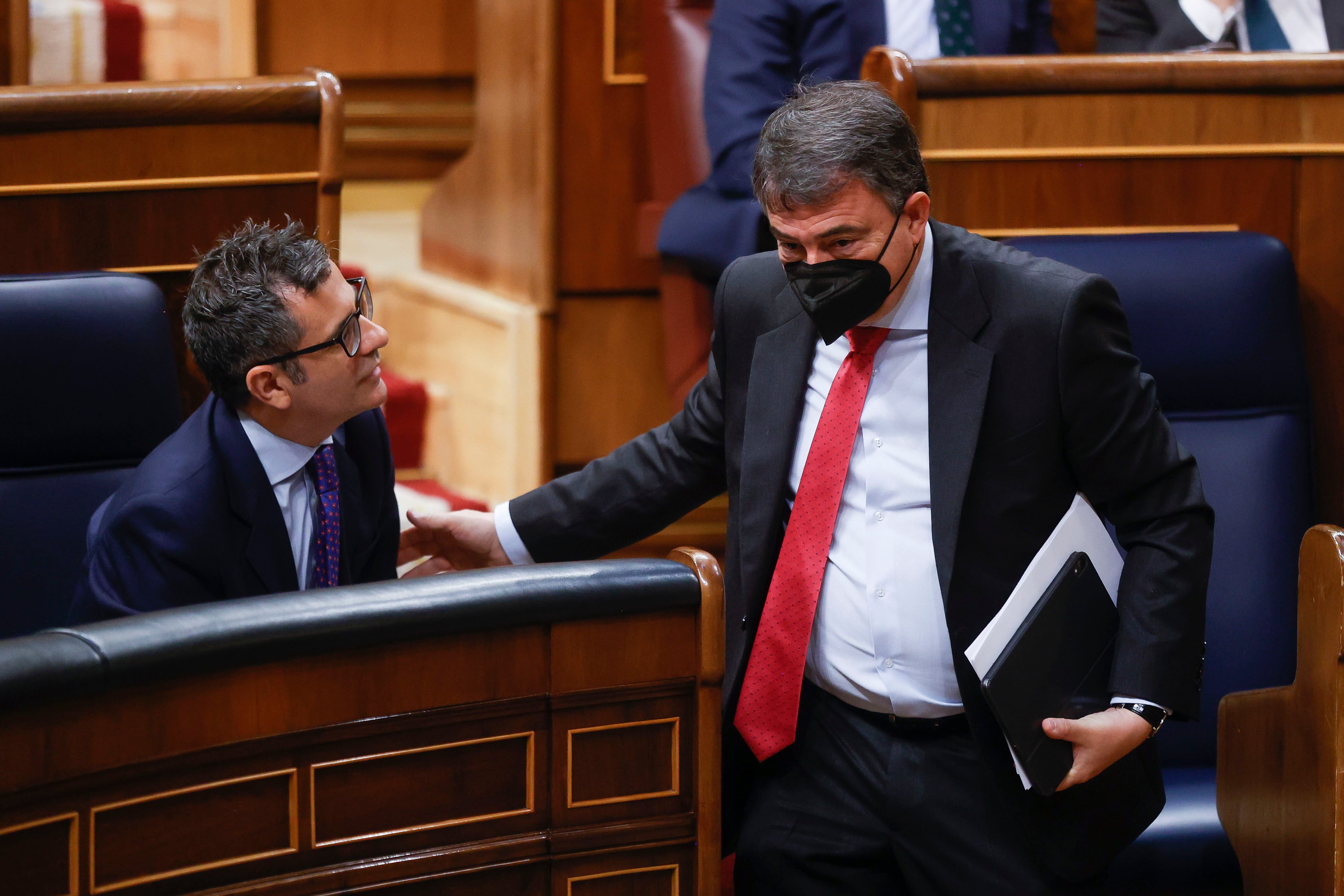 El portavoz del PNV Aitor Esteban saluda al ministro Bolaños (i) durante el pleno celebrado este jueves en el Congreso. 