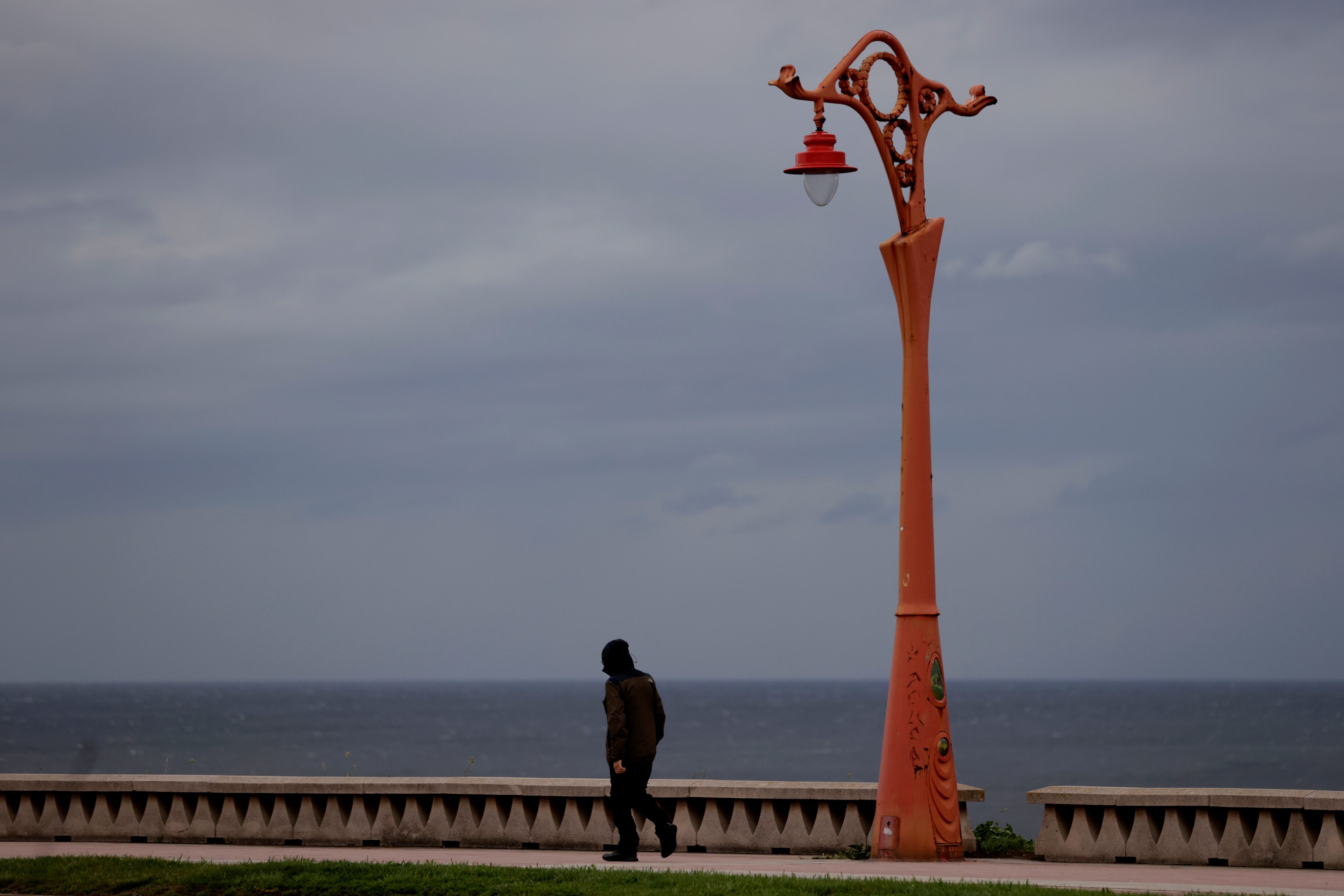 A CORUÑA, 17/10/2023.- Un hombre camina este martes por el paseo marítimo de A Coruña, en una jornada de inestabilidad con borrascas, especialmente en el oeste peninsular, que vendrán acompañadas por fuertes vientos. EFE/Cabalar
