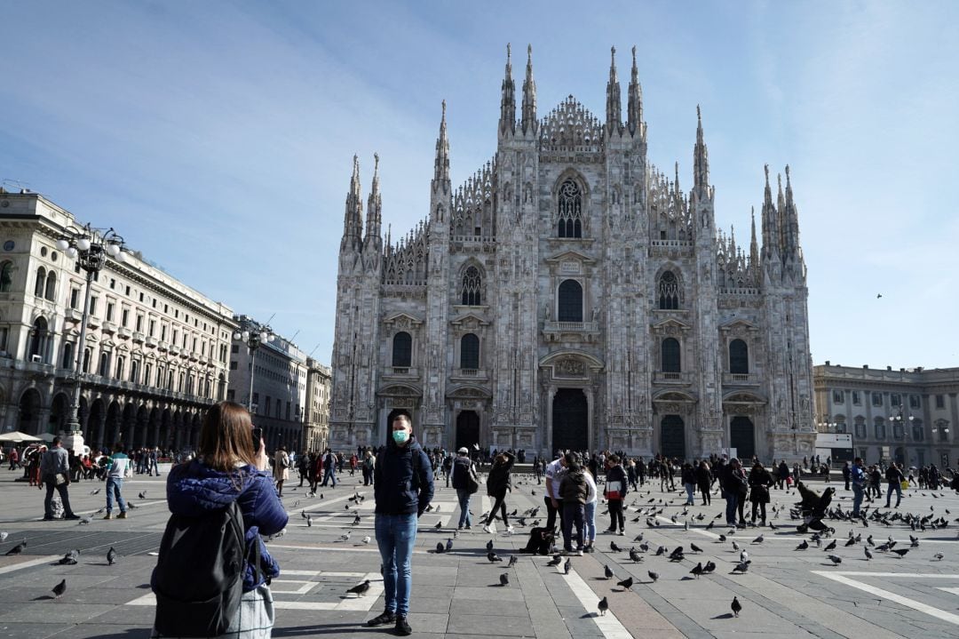 Un turista se toma una fotografía frente a Il Duomo de Milán 