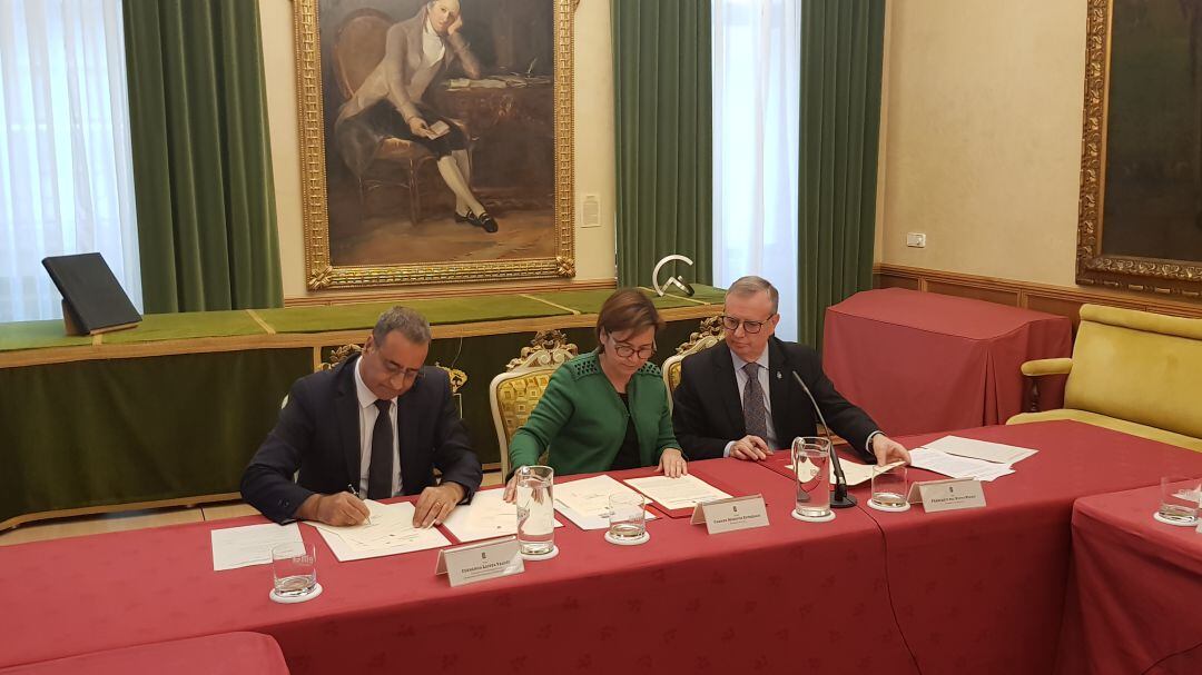 La alcaldesa, Carmen Moriyón, entre los consejeros de Infraestructuras y Sanidad, Fernando Lastra y Francisco del Busto, durante la firma del convenio de cesión. 