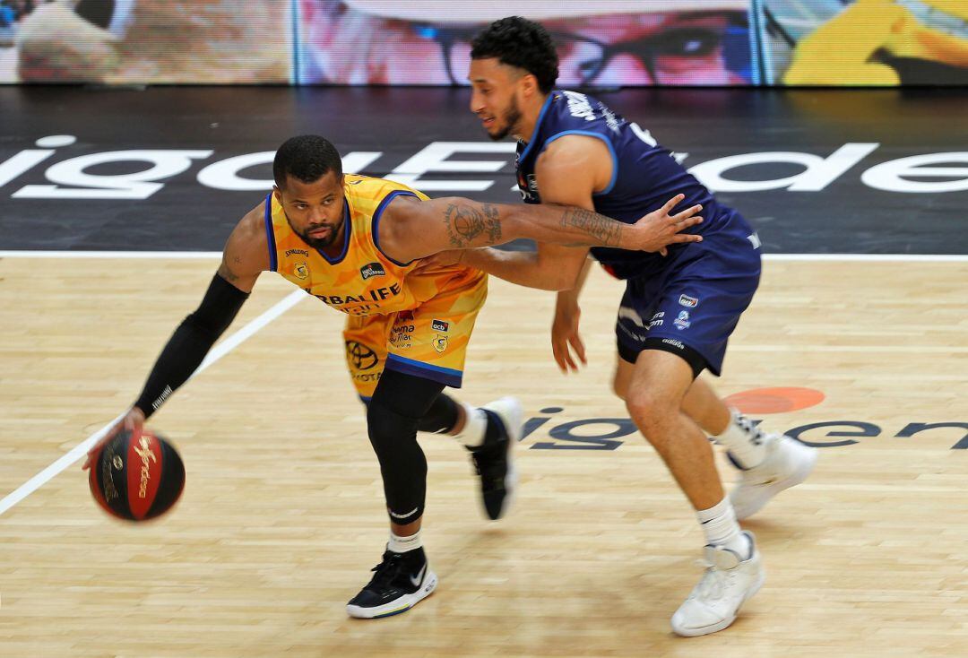  El base estadounidense del Herbalife Gran Canaria, Omar Cook, conduce el balón ante el base estadounidense del Mora Banc Andorra, Jeremy Senglin, durante la disputa del segundo partido de la segunda jornada del grupo B de la fase final de la Liga ACB que disputan en el pabellón de la Fuente de San Luis de Valéncia. 