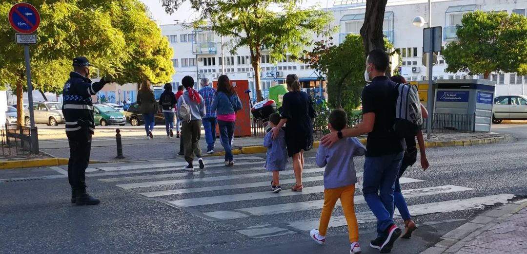 Un agente regula el tráfico a la entrada de un colegio