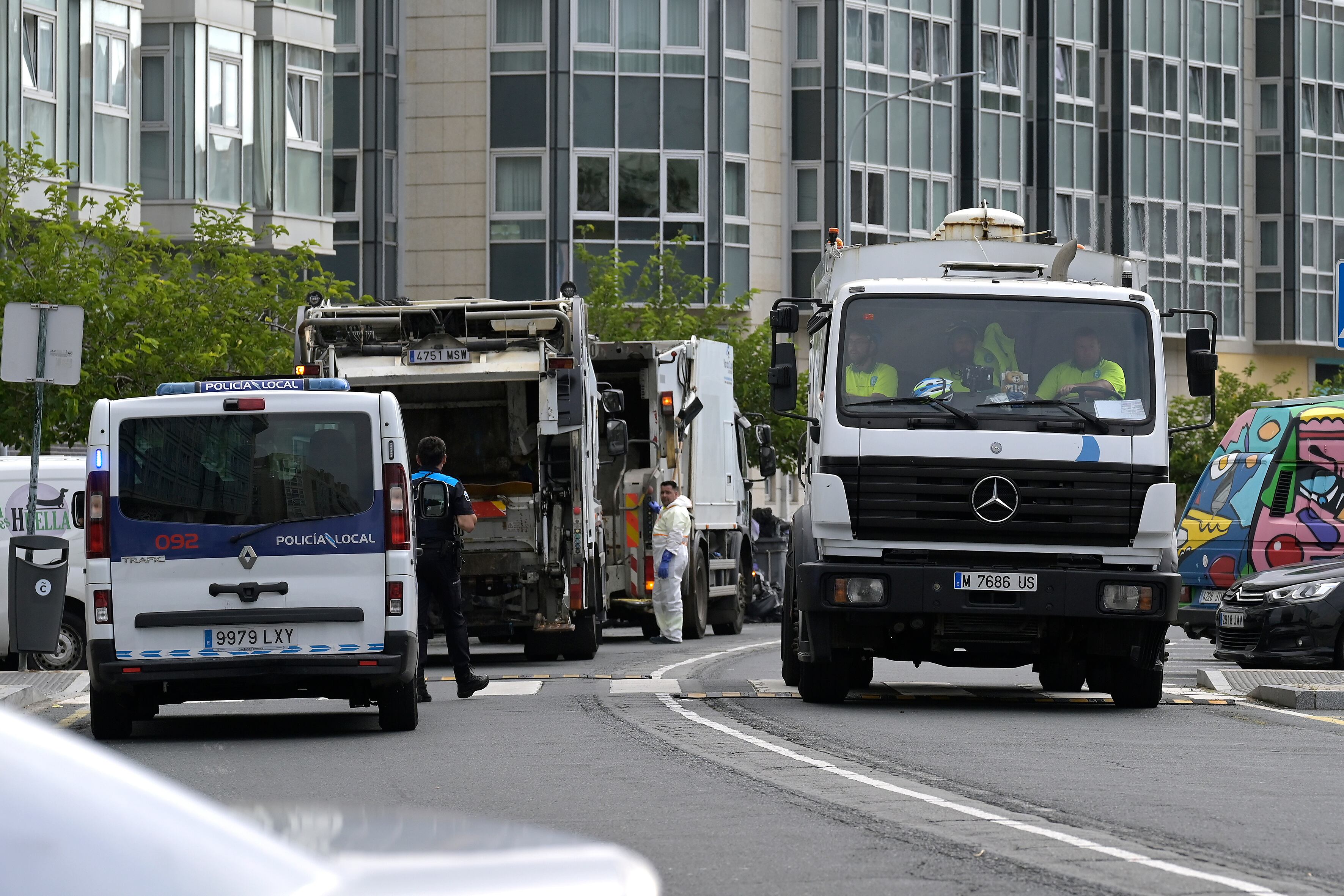 La empresa Valoriza, a la que el Ayuntamiento de A Coruña ha contratado para recoger la basura durante la situación de emergencia sanitaria, ha iniciado sus labores en varias calles de la ciudad y sus camiones van acompañados de escolta policial. Cinco vehículos de Valoriza ya han empezado a retirar basura en puntos especialmente sensibles, como en las proximidades de los centros sanitarios, y en puntos críticos de insalubridad en los que se han acumulado los residuos durante las últimas semanas. EFE/ Moncho Fuentes