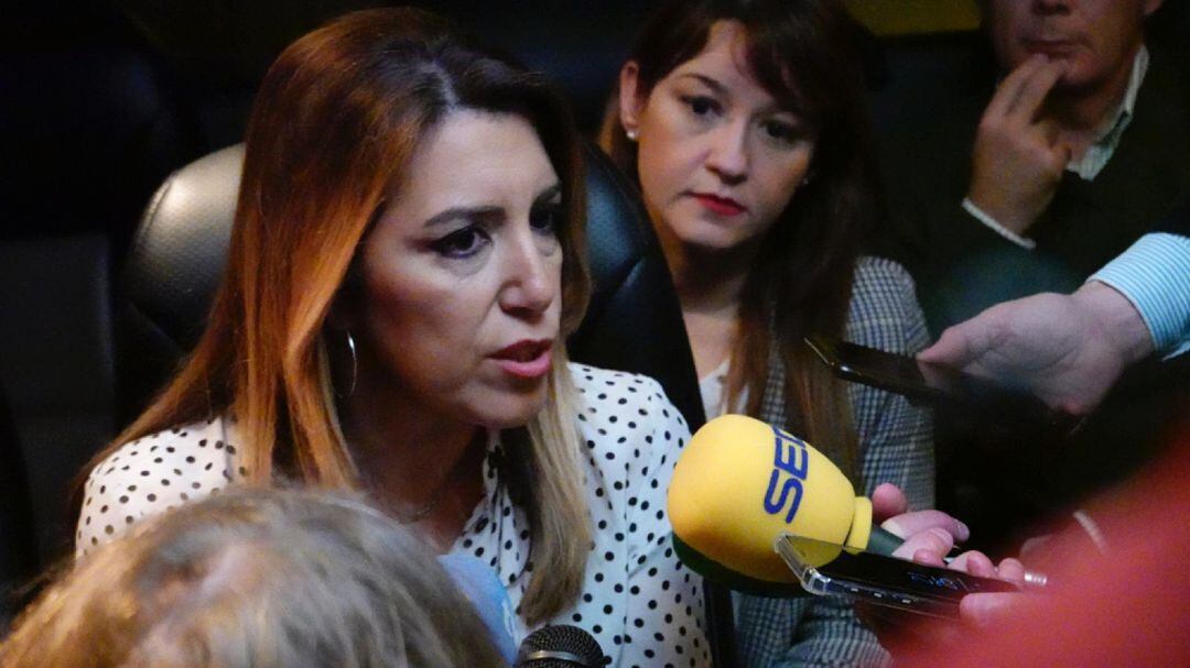 Susana Díaz explica a los periodistas que siguen su caravana electoral los motivos que han llevado al PSOE a suspender el mitin de San Juan de Aznalfarache por la protesta violenta de un centenar de taxistas a las puertas del teatro en el que se iba a cel