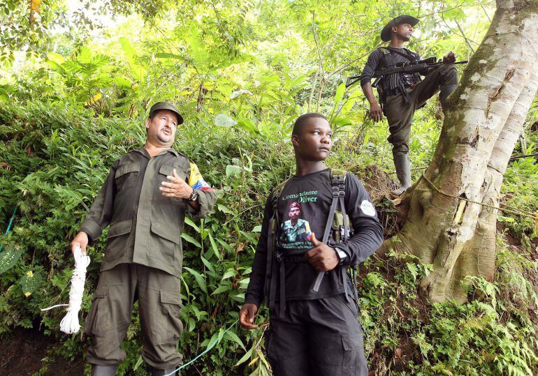 Fotografía del 8 de marzo de 2017 del guerrillero de las Farc Emilio (i) y John Valencia (c) durante una entrevista con Efe en el campamento temporal de la vereda La Variante, municipio de Tumaco (Colombia). En las filas de las FARC desde que tenía diez a