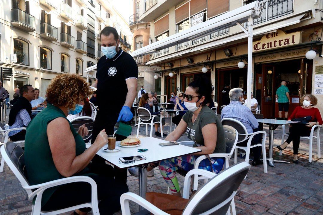 Imagen de archivo de un camarero atendiendo una terraza en Málaga.