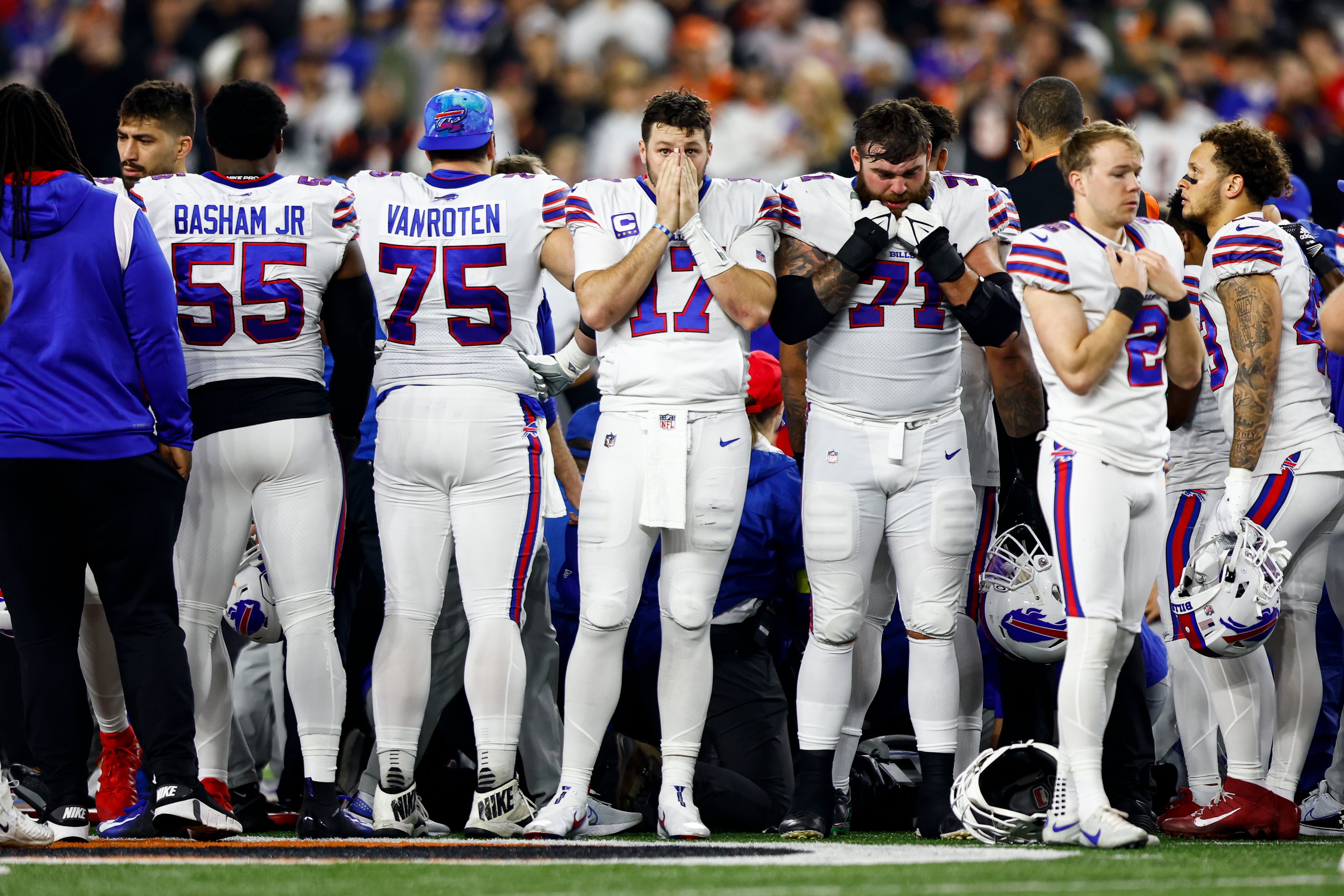 Los jugadores de los Buffalo Bills rodean a los sanitarios que atienden a Damar Hamlin